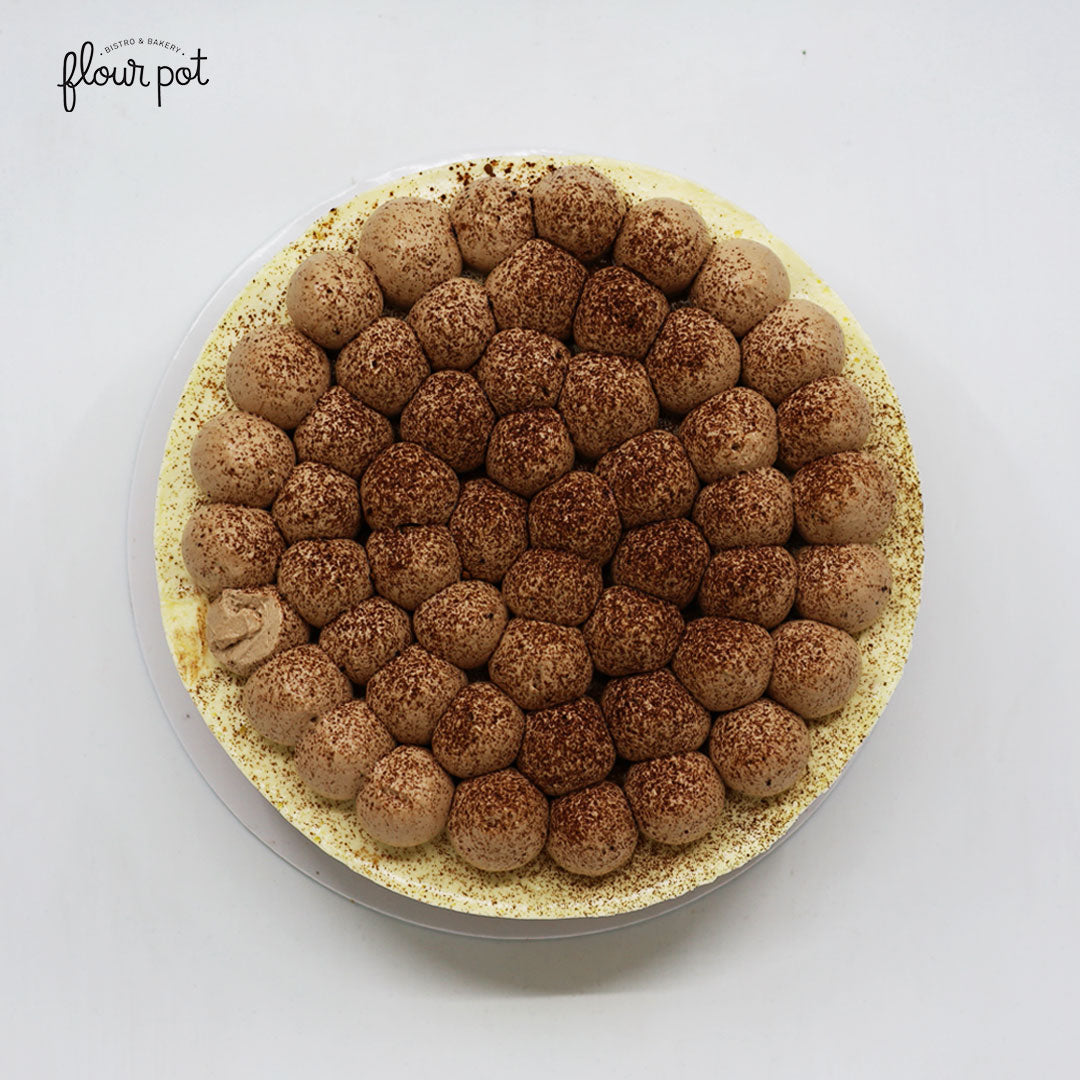 Banana Fromage Cake topped with banana cream domes and cocoa powder